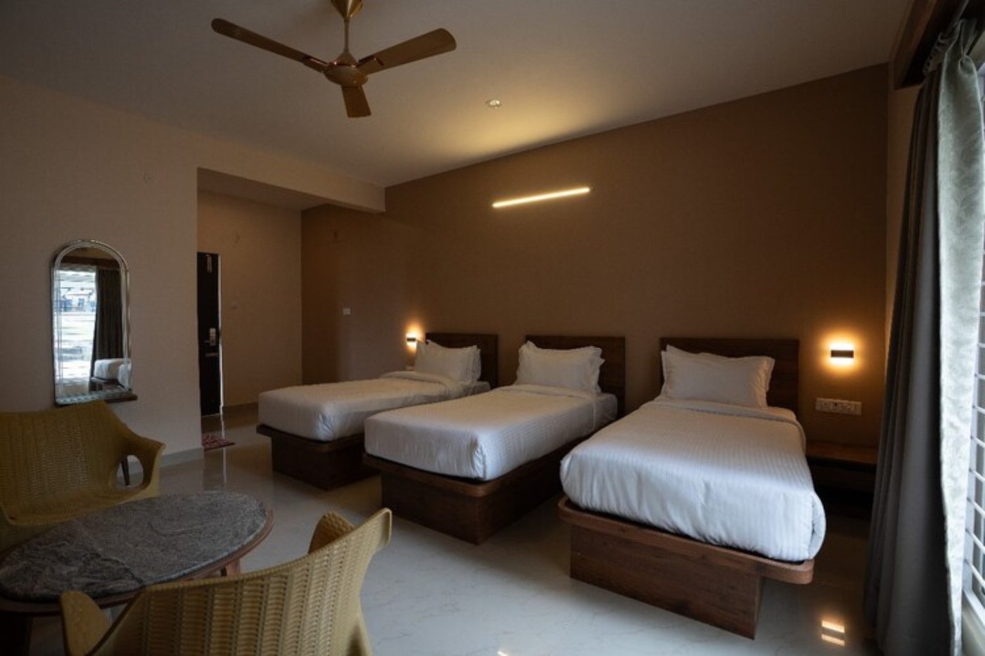 Triple suite room with ceiling fan at a budget resort in Yelagiri